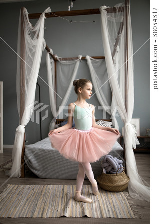 Cute little ballerina is dancing in the room. 38054312