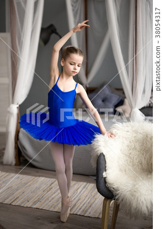 girl in a blue ballet costume dancing in a room. 38054317