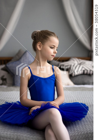 girl in a blue ballet costume dancing in a room. 38054319