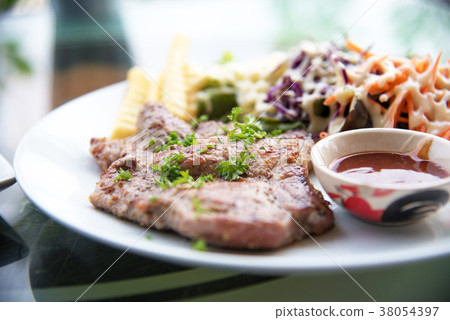Pork chop steak with salad and gravy sauce in dish 38054397