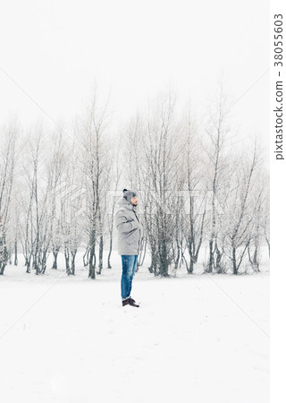 a man in a gray jacket in a winter forest 38055603