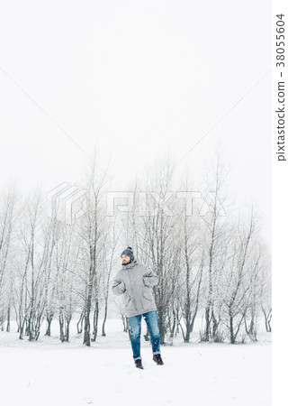 a man in a gray jacket in a winter forest 38055604