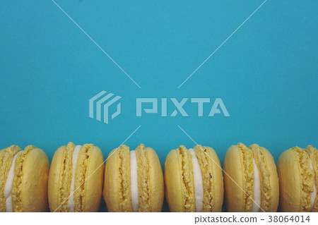 Flat lay yellow macaroons on blue background Flat lay yellow macaroons on blue background 38064014
