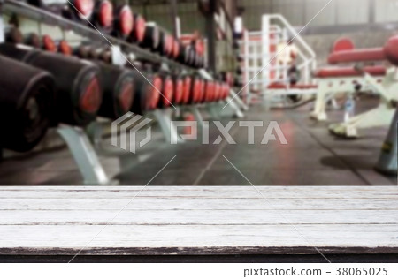 Wooden table on blurred background of fitness gym interior of mo Wooden table on blurred background of fitness gym interior of mo 38065025