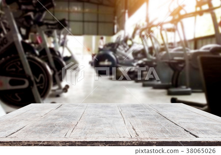 Wooden table on blurred background of fitness gym interior of mo Wooden table on blurred background of fitness gym interior of mo 38065026