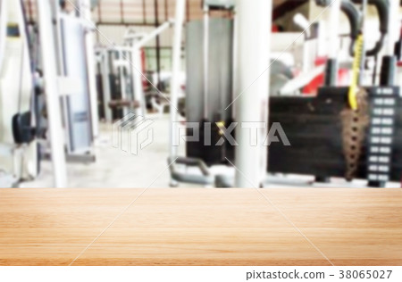 Wooden table on blurred background of fitness gym interior of mo Wooden table on blurred background of fitness gym interior of mo 38065027
