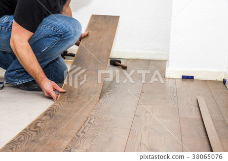 Man laying laminate in socks 38065076