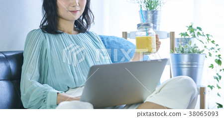 Woman using a computer on the sofa 38065093