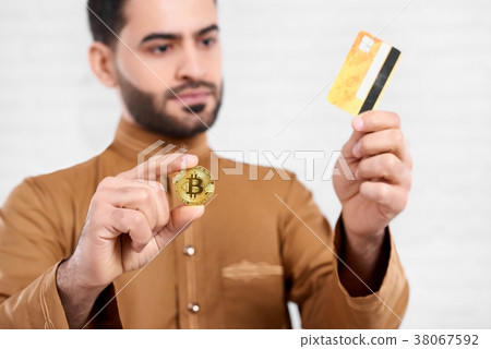 Arabian businessman keeps credit card and a golden Arabian businessman keeps credit card and a golden 38067592