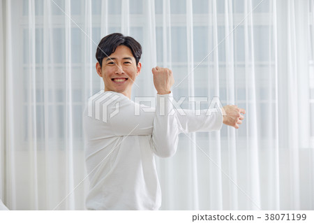 Twenties man stretching, stretching, stretching, stretching in bed 38071199