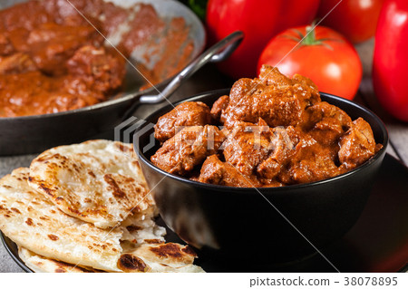 Chicken tikka masala served with bread naan 38078895