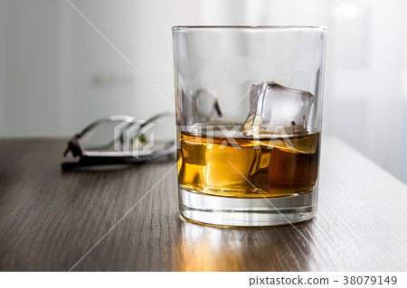 Glass of whiskey, brandy, cognac with ice cubes on Glass of whiskey, brandy, cognac with ice cubes on 38079149