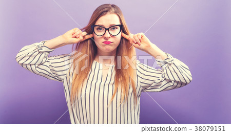 Young woman blocking her ears Young woman blocking her ears 38079151
