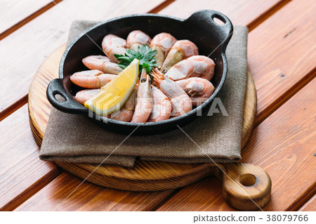 Boiled shrimp with lemon and parsley on a wooden 38079766