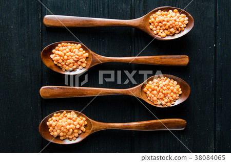 Spoons filled with uncooked lentil for soup 38084065