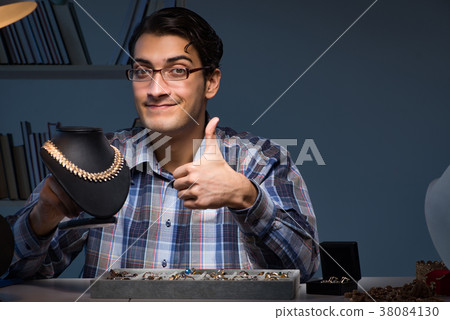 Young male jeweller working at night in his Young male jeweller working at night in his 38084130