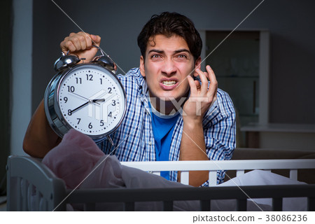 Young father under stress due to baby crying at 38086236