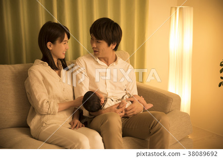 Couple holding baby in night living Couple holding baby in night living 38089692