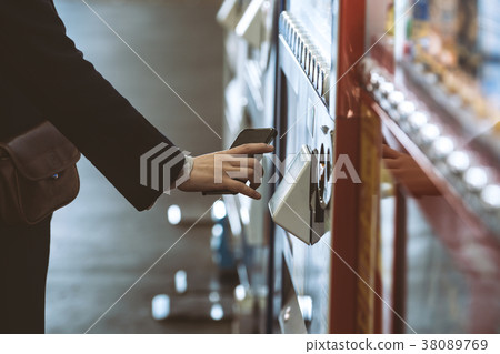 Woman using electronic money at vending machine Woman using electronic money at vending machine 38089769
