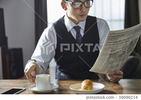 Stylish businessman drinking coffee while reading English newspaper Stylish businessman drinking coffee while reading English newspaper 38090214