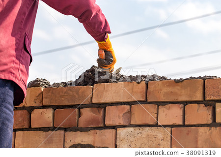 Worker builds a brick wall in the house Worker builds a brick wall in the house 38091319