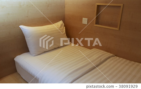Bed in small simple hotel bedroom 38091929