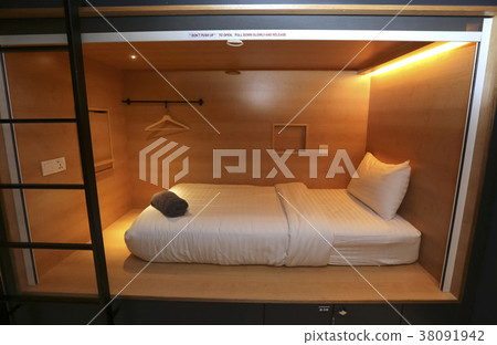 Bed in small simple hotel bedroom 38091942