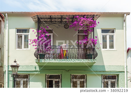 The balcony is decorated with purple flowers The balcony is decorated with purple flowers 38092219