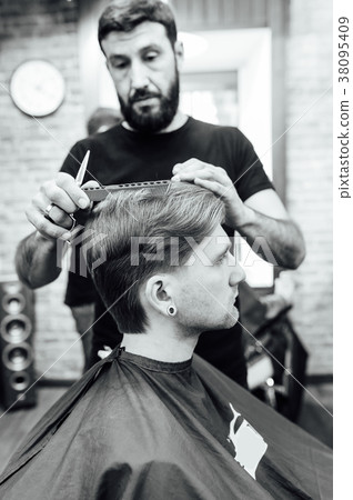 man getting trendy haircut at barber shop. 38095409
