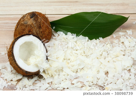 Coconut cut in half and coconut flakes around Coconut cut in half and coconut flakes around 38098739