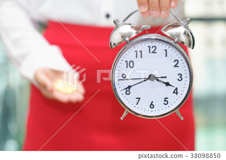 Woman holding a clock with medicine Woman holding a clock with medicine 38098850