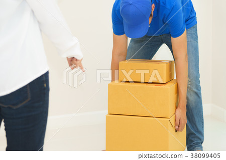 Deliveryman holding boxes into customer home - receiving packag Deliveryman holding boxes into customer home - receiving packag 38099405