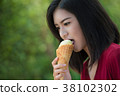 Asian women are eating mud ice cream. 38102302
