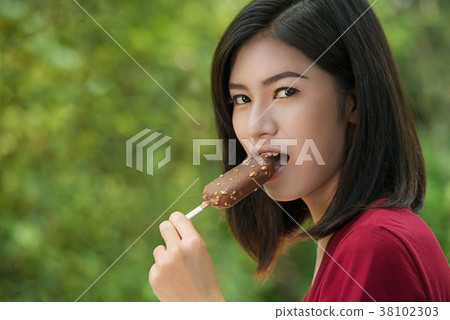 Asian women are eating delicious ice cream. 38102303