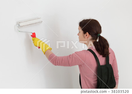 Female worker painting wall in a room Female worker painting wall in a room 38103520