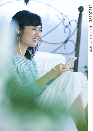 Woman listening to music with smartphone and earphones 38107813