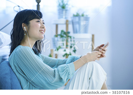 聽到與智能手機和耳機的音樂的婦女 38107816