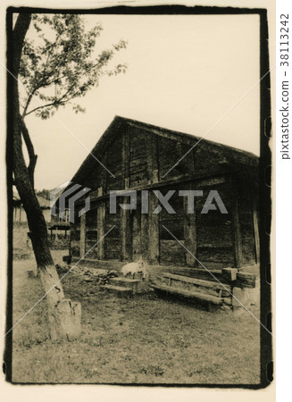 The goat lies on the steps of the wooden house. The goat lies on the steps of the wooden house. 38113242