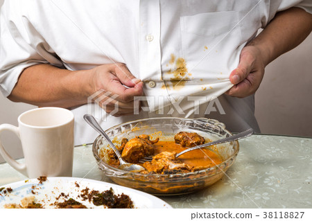 Person accidently spilled curry onto white shirt. 38118827