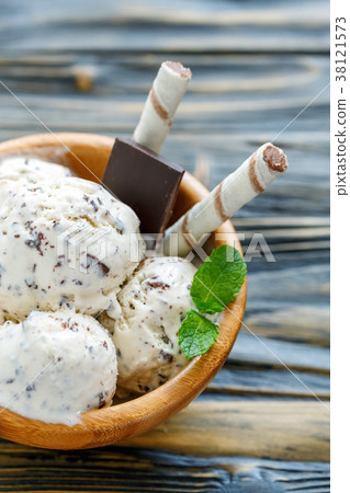 Ice cream with chocolate crumb in a wooden bowl. 38121573