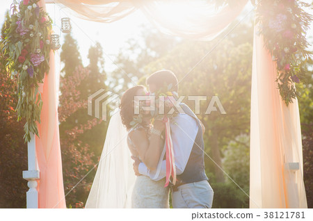 Happy couple kissing under the textile arch 38121781