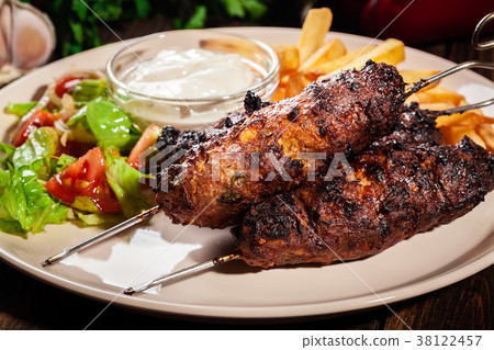 Grilled shish kebab served with fried chips 38122457
