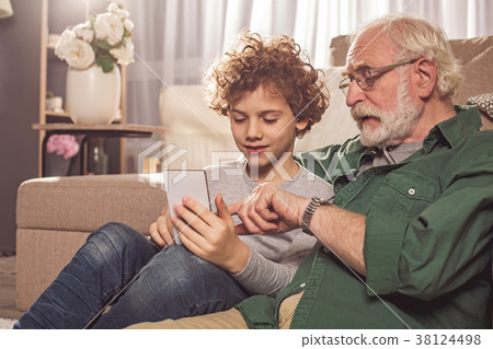 Happy kid and grandfather looking at phone Happy kid and grandfather looking at phone 38124498