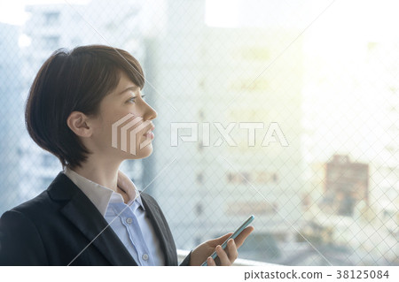 A woman watching a smartphone 38125084