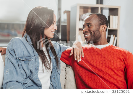 Smiling enamored man and woman sitting together 38125091