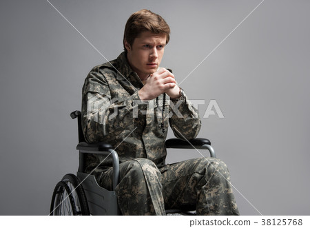 Upset disabled military man holding rosary Upset disabled military man holding rosary 38125768