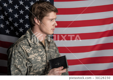 Calm male soldier having book in hand 38126150