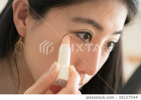 Young woman painting a concealer 38127544