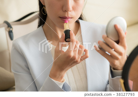 Business woman holding compact and doing makeup again Business woman holding compact and doing makeup again 38127793