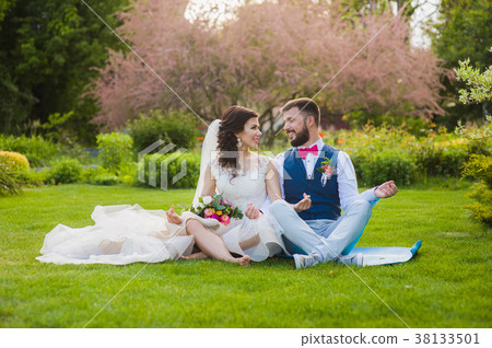 Groom and bride in yoga lotus pose in garden Groom and bride in yoga lotus pose in garden 38133501